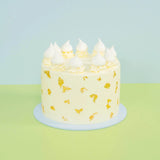 White Gold Wedding Cake with smooth white buttercream, real edible gold leaf, and delicate meringue toppings by Crumbs & Doilies.